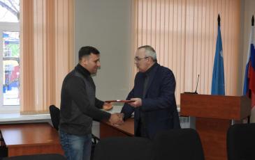 Мэр Поронайского городского округа Александр Радомский вручает награду